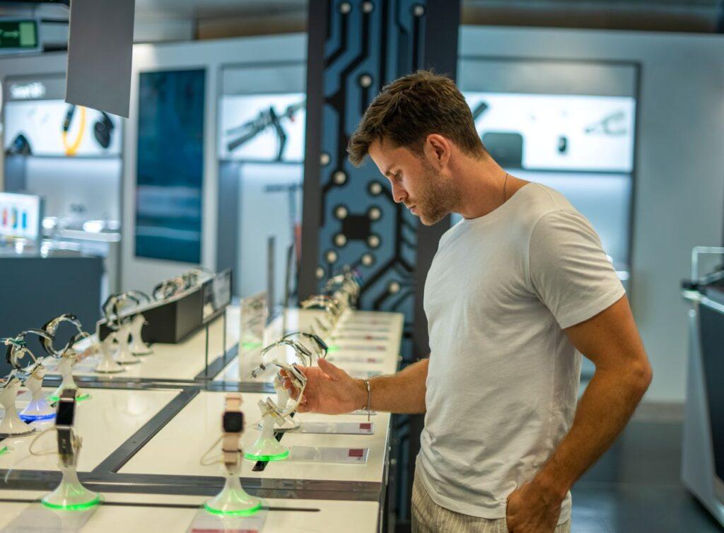 Ein Mann prüft Smartwatches im Laden – zeigt das Zusammenspiel von Technikbegeisterung und Lifestyle-Produkten wie vape im modernen Konsum.